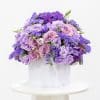 Purple flower arrangement in a white pot