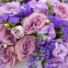 Purple flower arrangement in a white pot